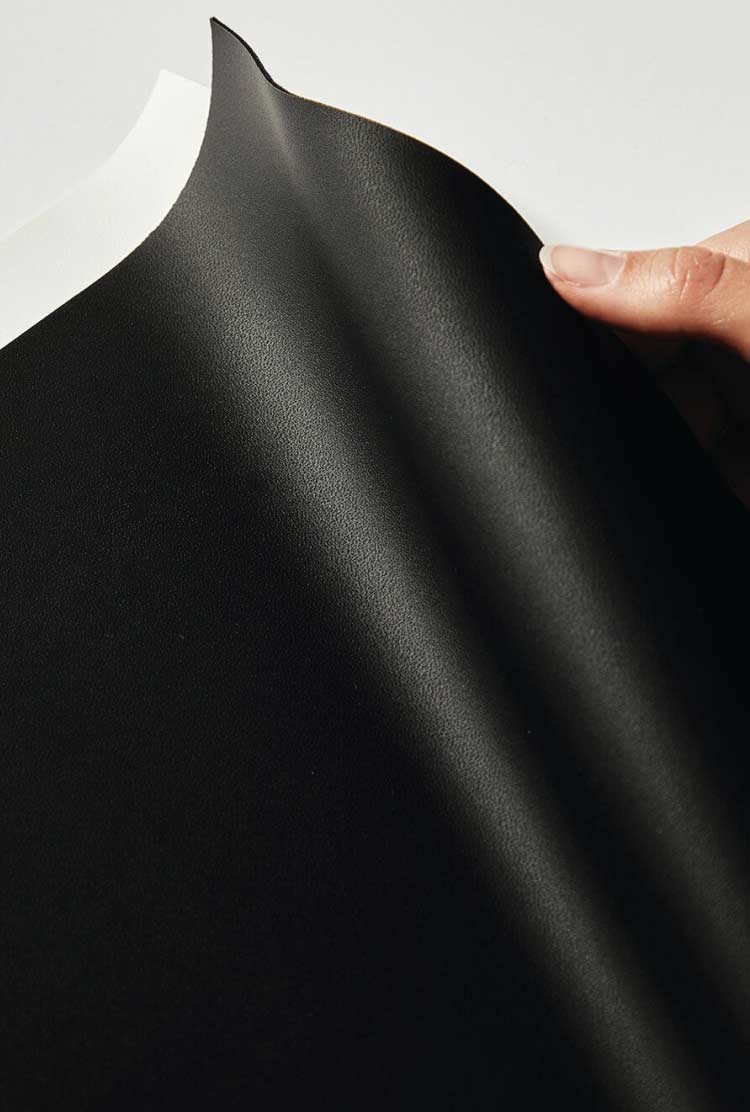 Background image: Hand holding material swatch