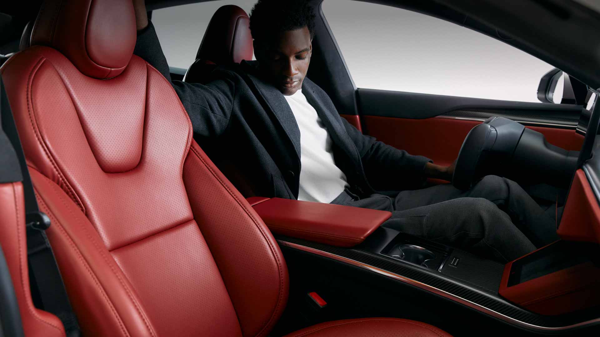 Person looking at the Serrano Red interior of a Tesla