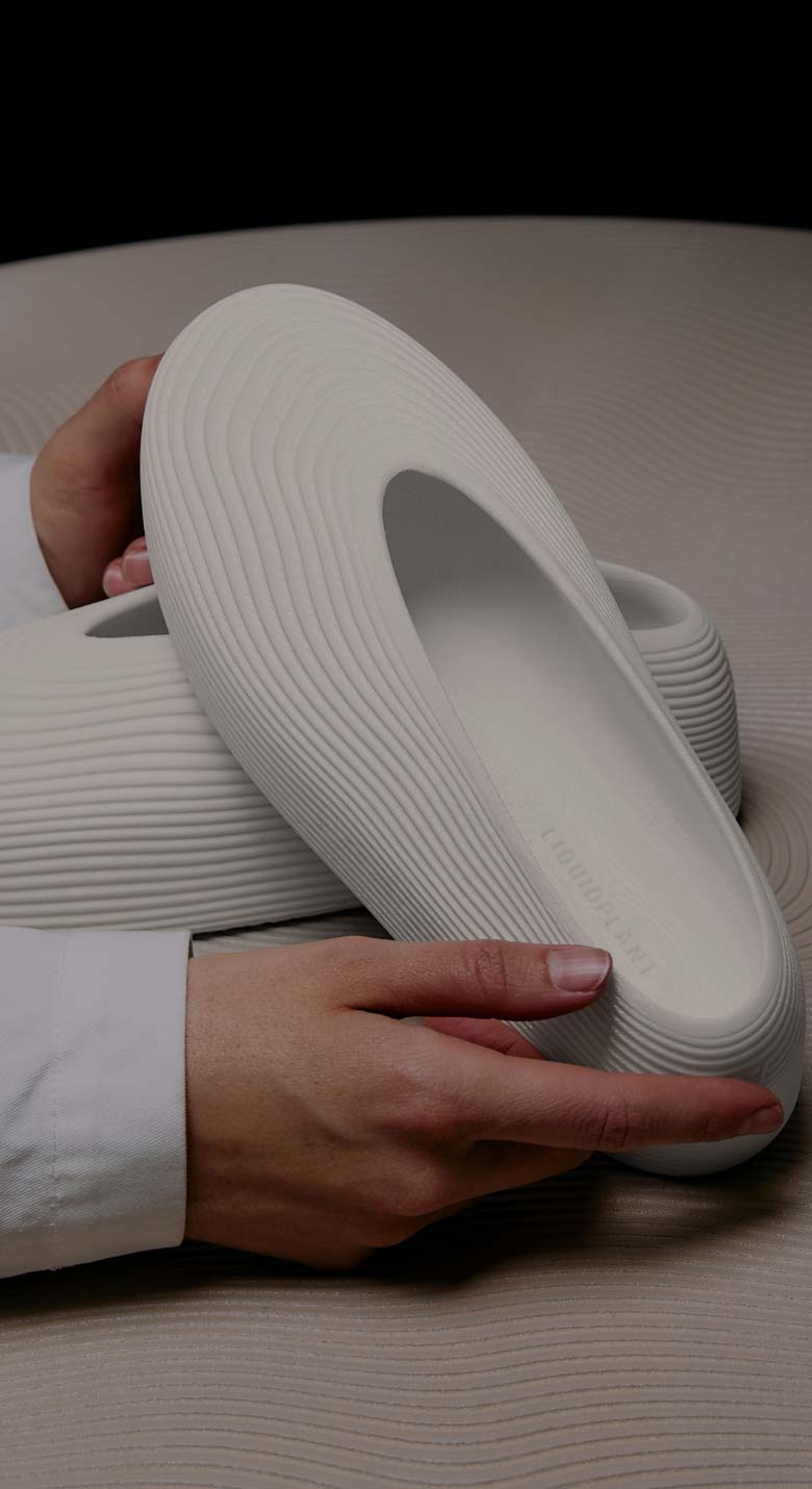 von Holznausen chemist in a lab coat holding a shoe made of Liquidplant in the laboratory