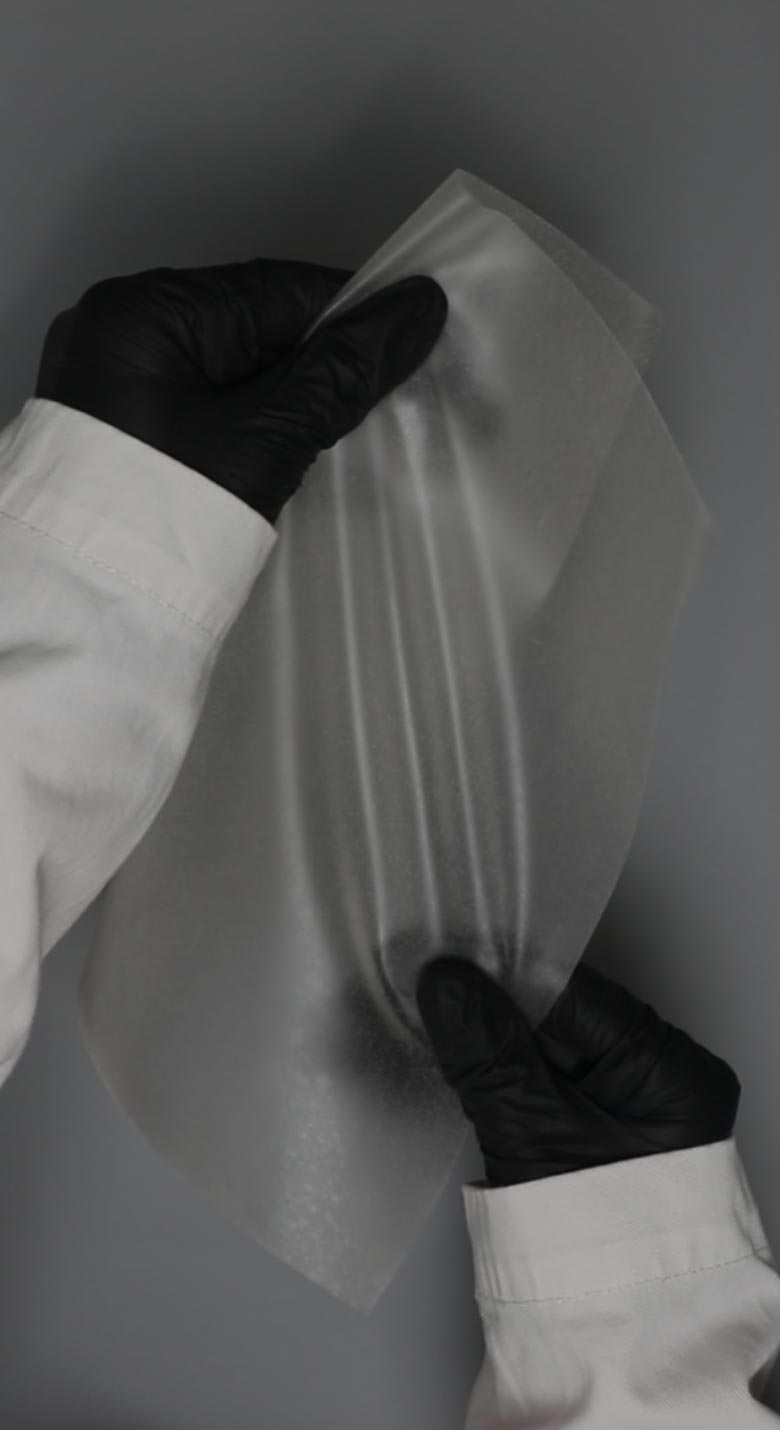 von Holznausen chemist in a lab coat holding a shoe made of Liquidplant in the laboratory