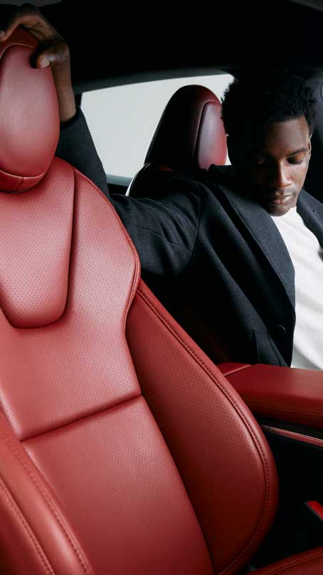Person looking at the Serrano Red interior of a Tesla